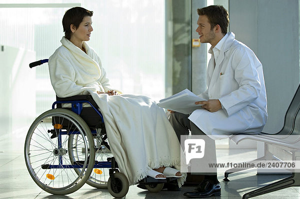 Seitenprofil eines männlichen Arztes im Gespräch mit einer Patientin