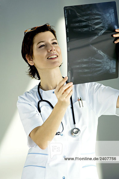 Ärztin untersucht einen Röntgenbericht und lächelt