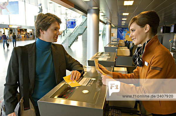 Businessman with a female check-in attendant at an airport check-in counter