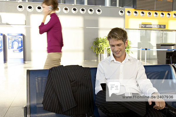 Businessman using a mobile phone at an airport lounge