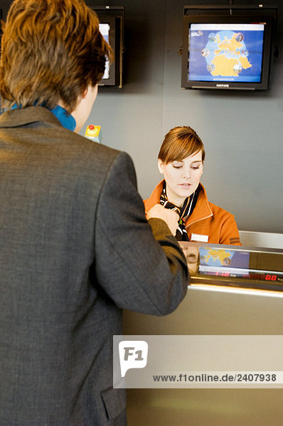 Rückansicht eines Geschäftsmannes an einem Flughafen-Check-in-Schalter