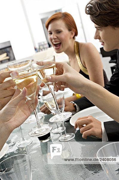 Close-up of human hands toasting with champagne at a dinner party