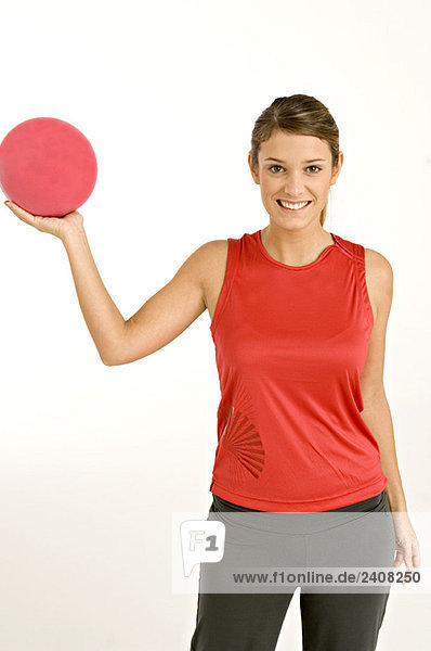 Porträt einer jungen Frau  die einen Ball hält und lächelt