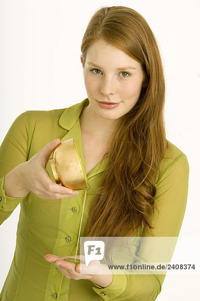 Portrait of a young woman pouring massage oil on her palm