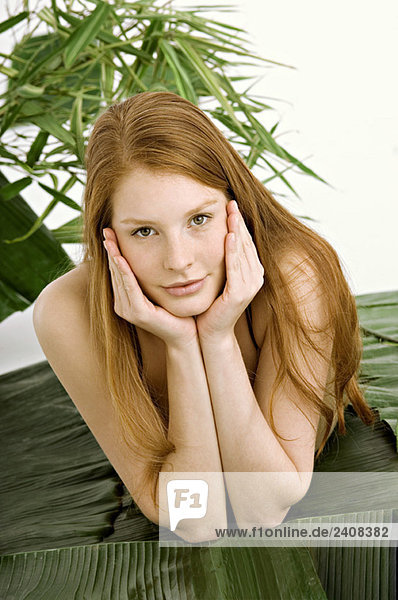 Portrait of a young woman lying on banana leaves