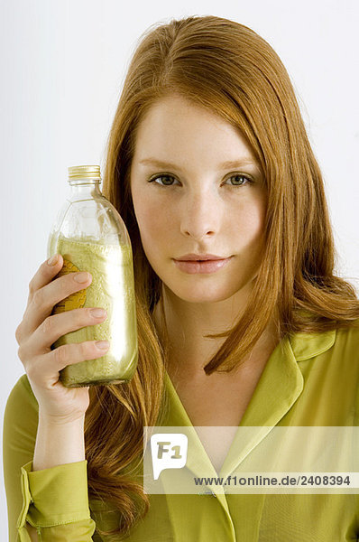 Porträt einer jungen Frau mit einer Flasche Aromatherapieöl