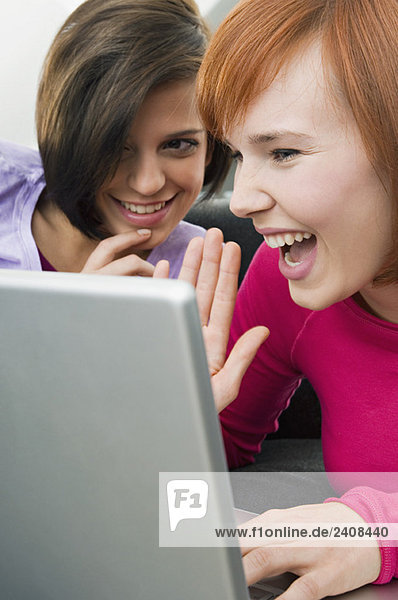 Two young women using a laptop