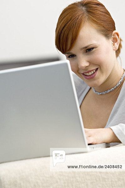 Nahaufnahme einer jungen Frau mit Laptop und Lächeln