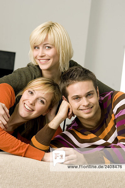 Portrait of a young man smiling with two young women