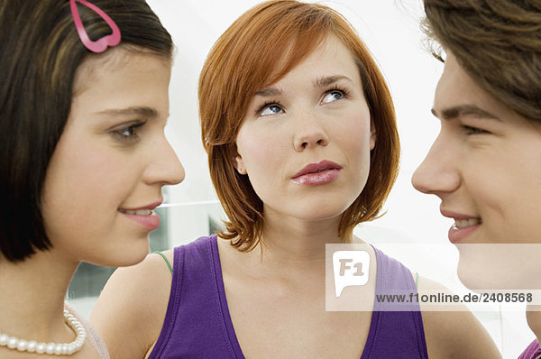 Seitenprofil eines Teenagers  der eine junge Frau mit einer anderen jungen Frau sieht.