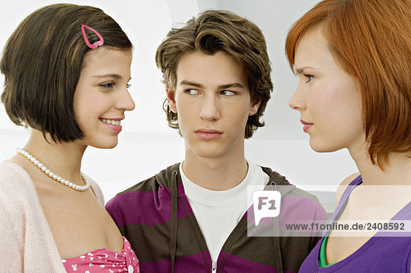 Close-up of a teenage boy with two young women