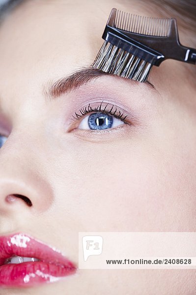 Woman brushing eyebrow