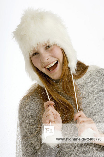 Portrait of a young woman wearing a fur hat and smiling