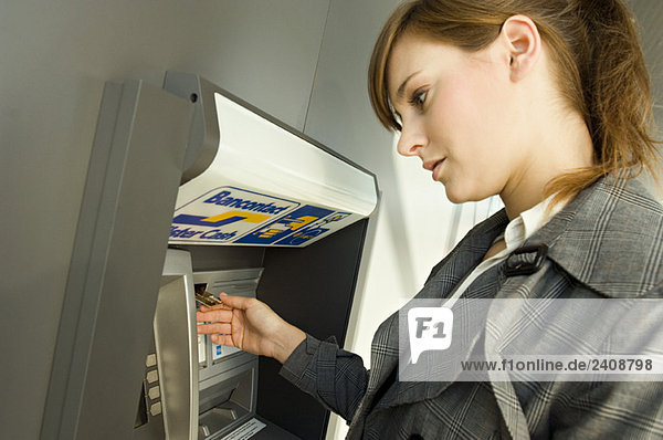 Side profile of a businesswoman using an ATM