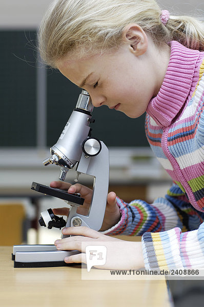 Seitenansicht Mädchen auf der Suche durch Mikroskop