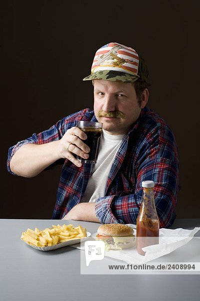 Stereotypischer Amerikaner mit Burger  Pommes frites und Cola