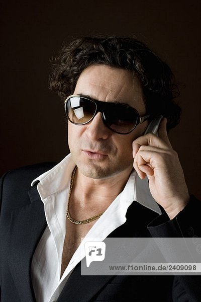 Stereotypical macho  sleazy man talking on a mobile phone