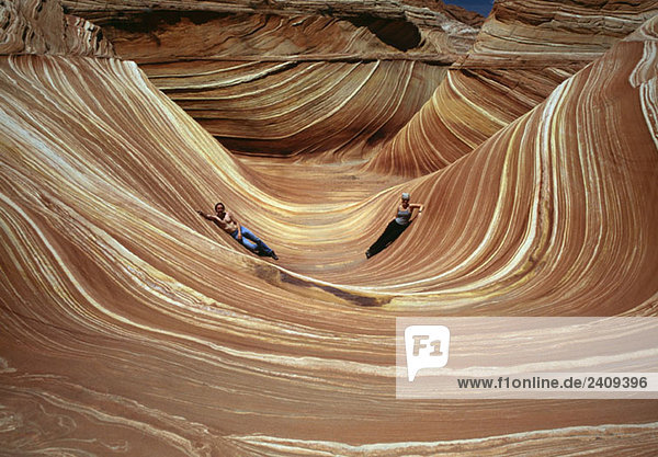 Zwei Menschen liegen in The Wave  Coyote Buttes  Paria Canyon-Vermilion Cliffs Wilderness  Arizona  USA.