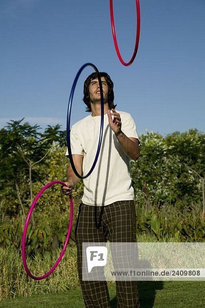 Ein junger Mann jongliert mit Reifen.