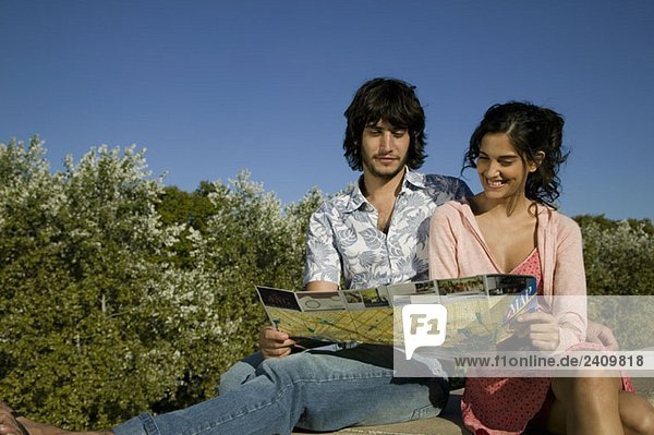 Ein junges Paar schaut auf eine Touristenkarte