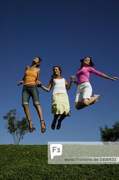 Drei Freunde springen in der Luft.