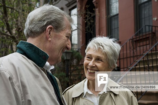 A senior couple outside of a brownstone