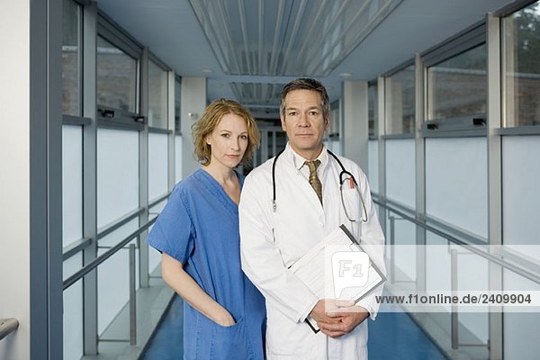 Two healthcare workers posing in a hospital corridor