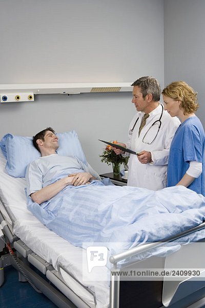 Zwei Mitarbeiter im Gesundheitswesen im Gespräch mit einem Patienten