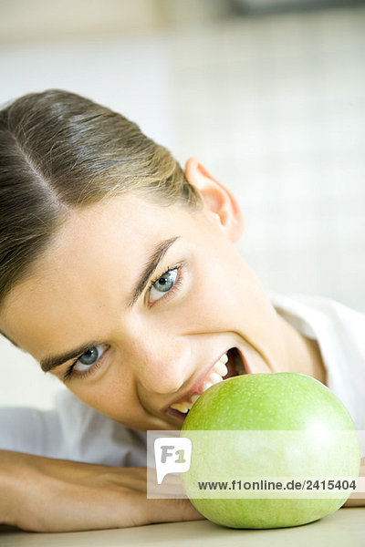 Young woman biting into apple