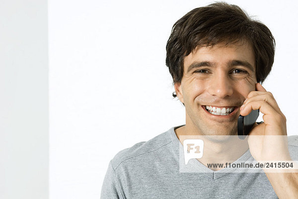 Mann mit Handy  lächelnd vor der Kamera