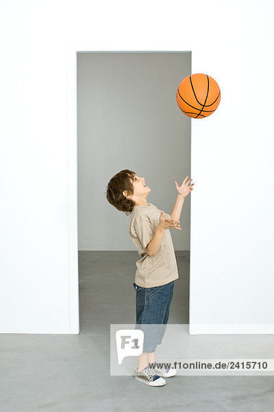 Junge wirft Basketball in die Luft