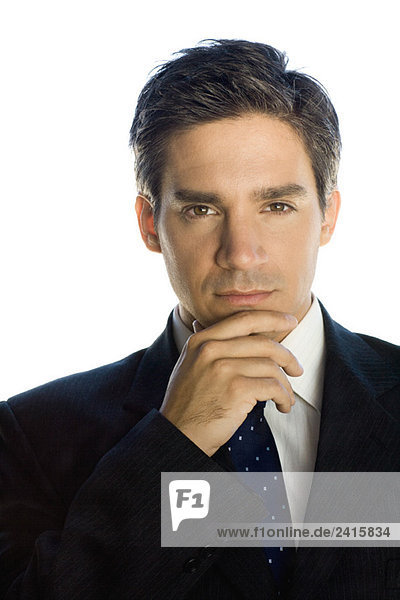 Businessman with hand under chin  looking at the camera  portrait