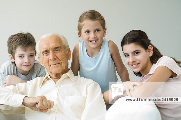 Großvater und drei Enkelkinder  alle lächelnd  Porträt