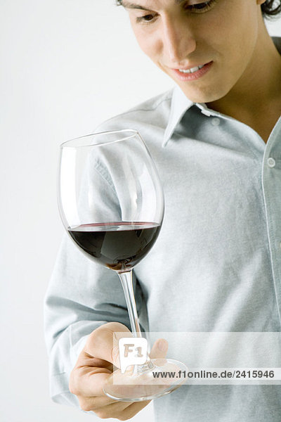 Man holding glass of red wine  cropped view