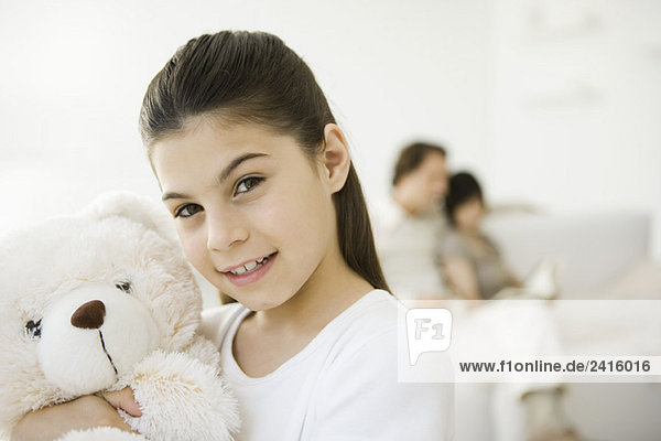 Kleines Mädchen mit Teddybär  lächelnd vor der Kamera