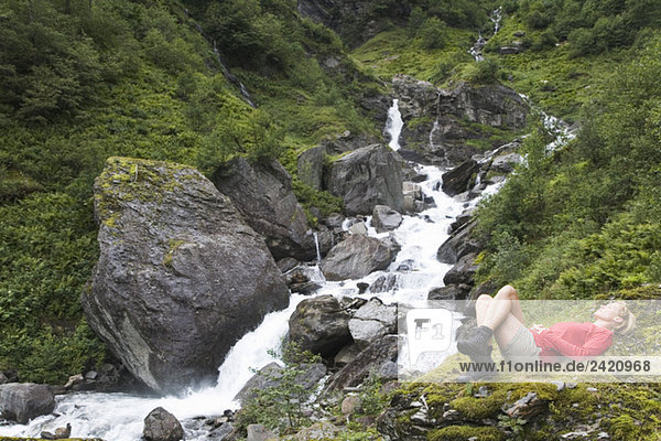 Frau entspannt am Wasserfall