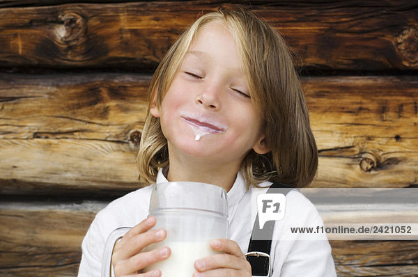 Österreich  Salzburger Land Junge (8-9) trinkt Milch  lacht  Portrait