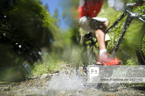 Mountainbiker überqueren Wasser  niedriger Abschnitt
