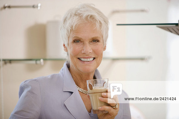Frau hält Trinkglas  lächelnd  Portrait