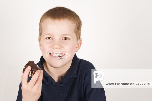 Junge (8-9) beim Essen eines Marshmallows  Portrait