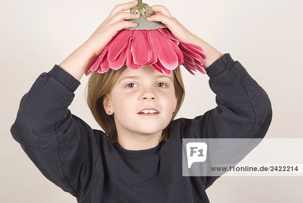 Blonder Junge (8-9) hält Blume über Kopf  Portrait