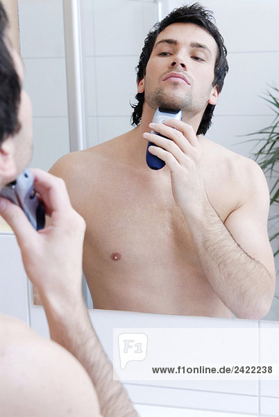 Young man man using electric razor  portrait