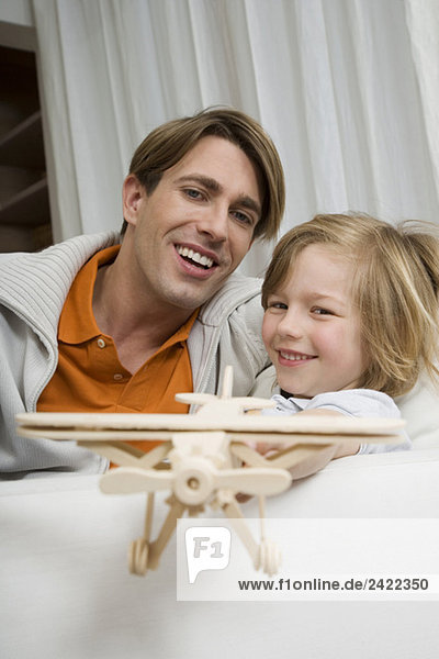 Vater und Sohn (8-9) spielen mit Modellflugzeug  Portrait