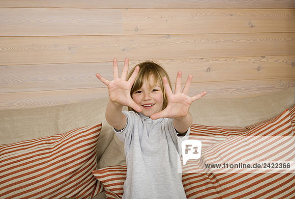 Junge (8-9) zeigt alle zehn Finger vor der Kamera  lächelnd  Portrait