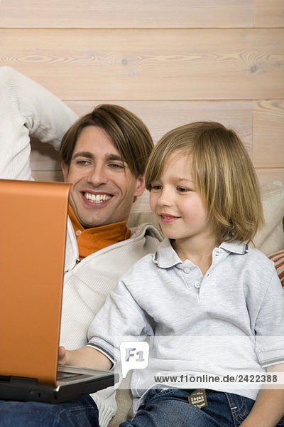Vater und Sohn (8-9) mit Laptop  Portrait