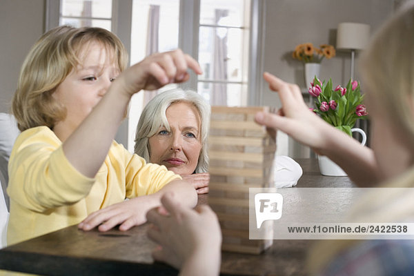 Großmutter und Enkelkinder (8-9) beim gemeinsamen Spielen