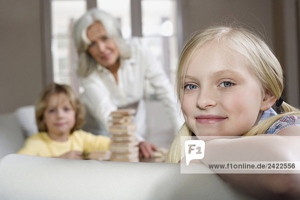 Großmutter und Enkel (8-9) spielen zusammen  Enkelin im Vordergrund  lächelnd  Portrait