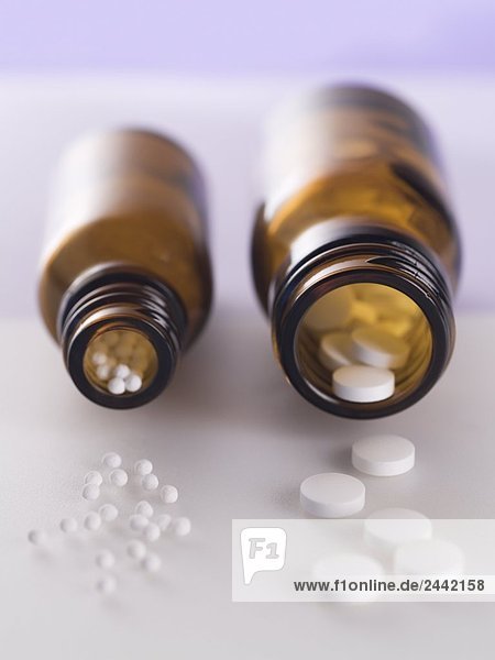 Nahaufnahme des homeopathic Pills spilling aus Flaschen