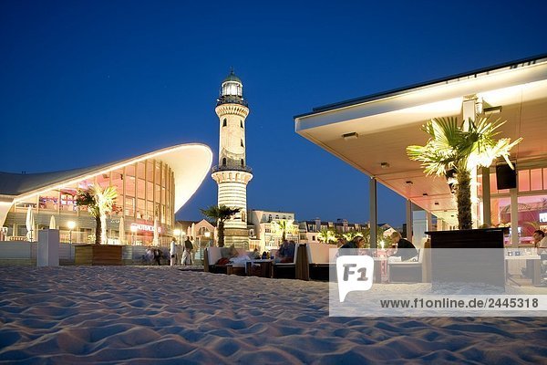 Leuchtturm und Restaurant beleuchtet in der Dämmerung  Schusters Strandbar  Warnemuende  Rostock  Mecklenburg-Vorpommern Deutschland