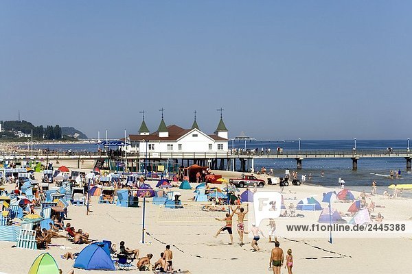 Tourists on beach with pier in background Ahlbeck Usedom Mecklenburg-West Pomerania Germany